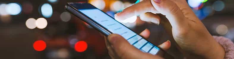 Person læser en smishing-sms på sin mobiltelefon