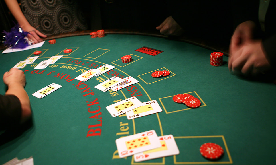 Dealer deler kort ud til spillere ved blackjack bord i online casino
